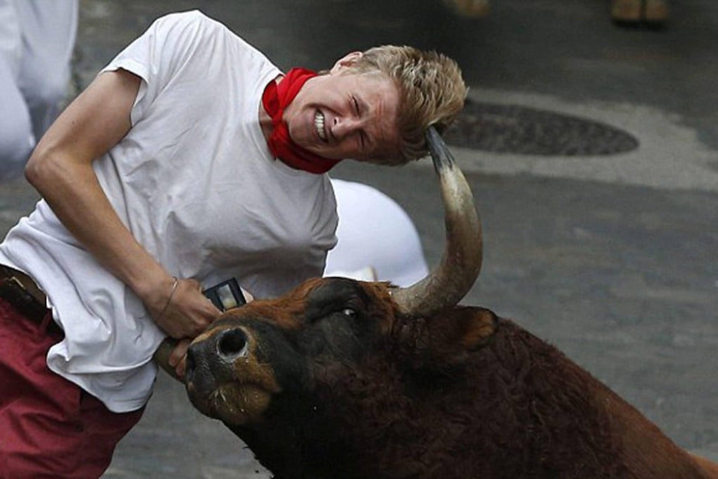 Patrick Eccles clings to his phone as he is gored last year. Photo: EPA