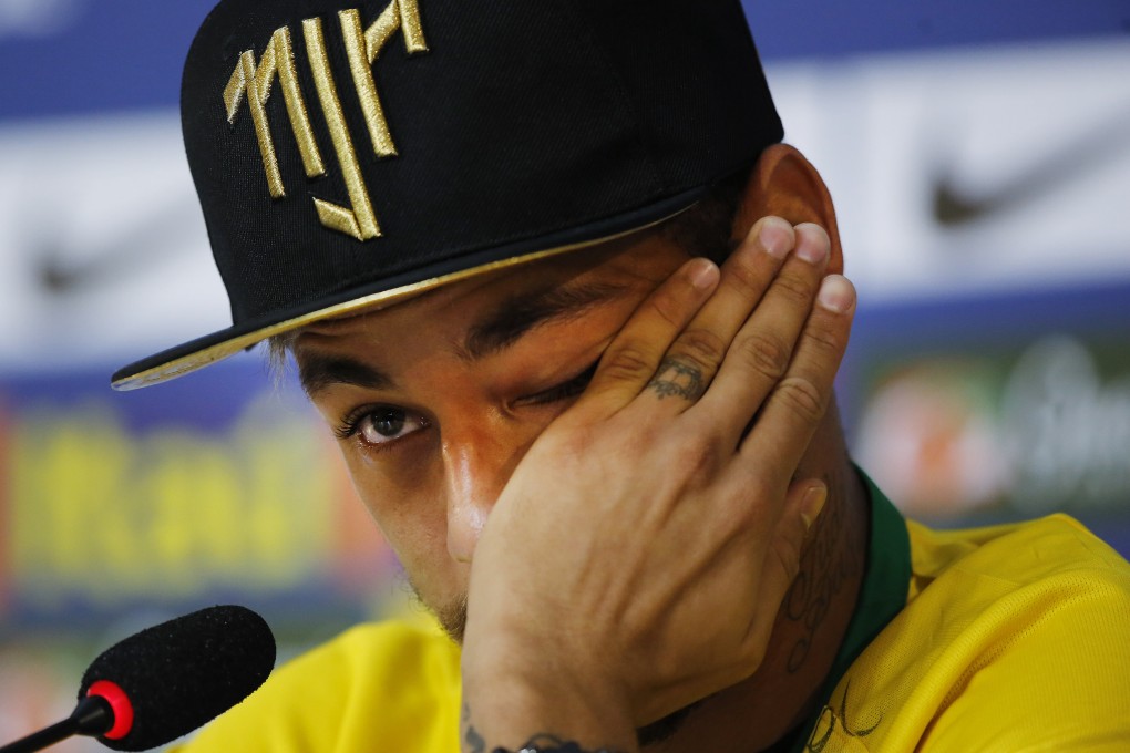 Neymar wipes away tears as he talks about the challenge that left him with fractured vertebra. Photo: AP