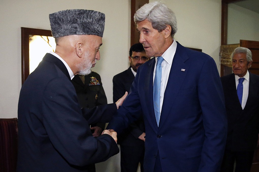 US Secretary of State John Kerry is greeted by Afghanistan's President Hamid Karzai as he arrives for a dinner at the presidential palace in Kabul on Friday. Photo: Reuters