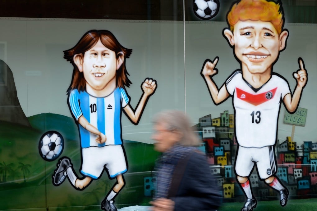 Caricatures of Argentina's Lionel Messi (left) and Germany's Thomas Mueller adorn the windows of a textile printing store in Frankfurt, Germany. Photo: EPA