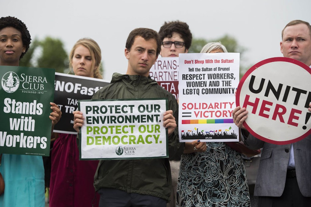 Activists stand with placards opposing the Trans-Pacific Partnership during a news conference. Photo: AFP