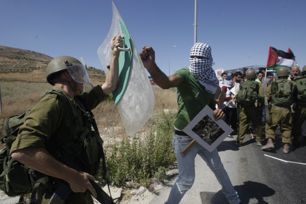 A Palestinian confronts an Israeli soldier during a demonstration against Israeli military action in Gaza. Photo: AP