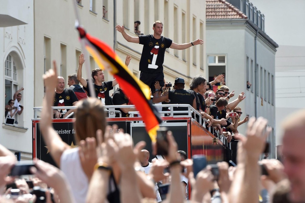 Germany goalkeeper Manuel Neuer gestures to fans during the drive along the so-called "Fan Meile" at Brandenburg Gate in Berlin on Tuesday. Photo: EPA