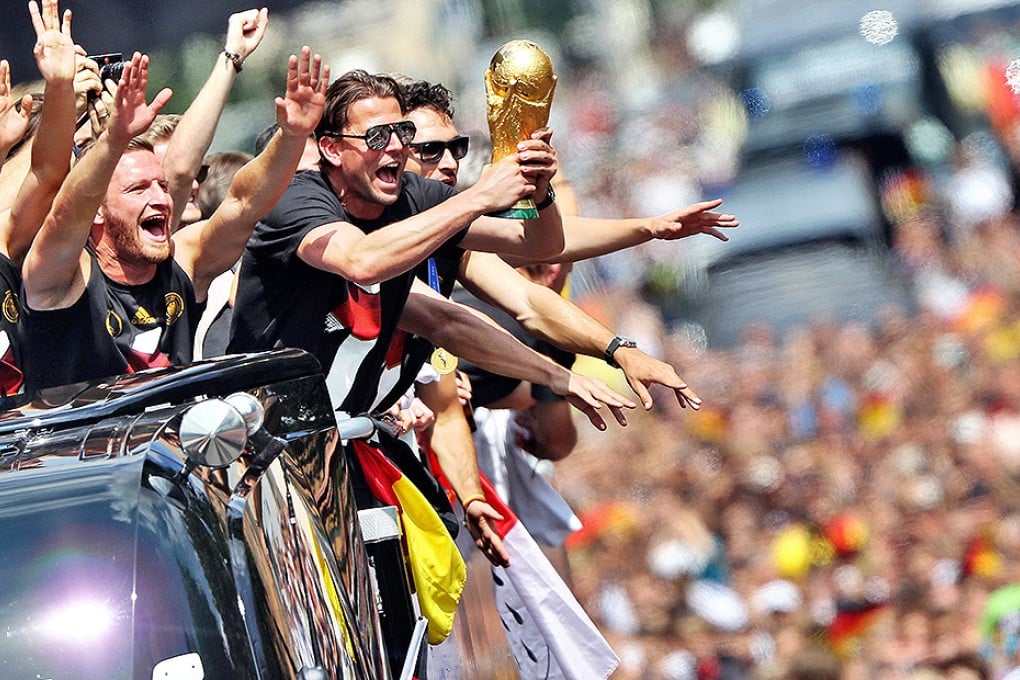 German national football team players ride in an open-deck bus to Berlin's  Brandenburg Gate to celebrate their World Cup title. Photo: AFP