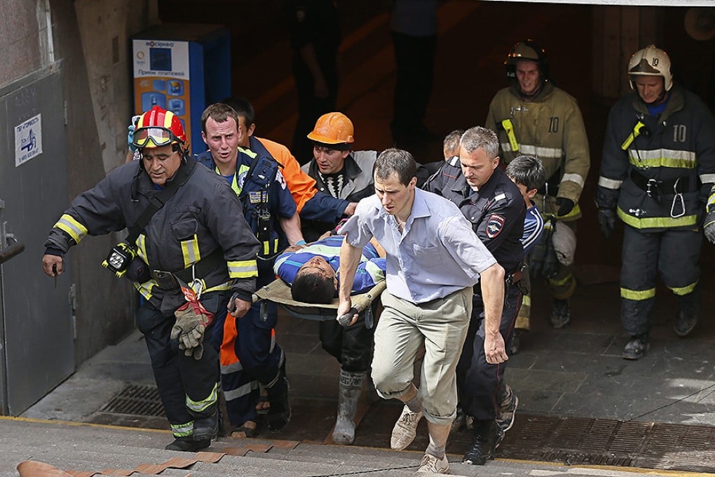 Rescue workers transport an injured passenger to an ambulance from Park Pobedy metro station. Photo: EPA