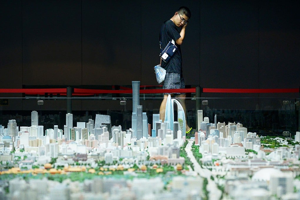 A visitor looks at a scale model of Beijing's urban development at an exhibition in Beijing. Photo: AFP