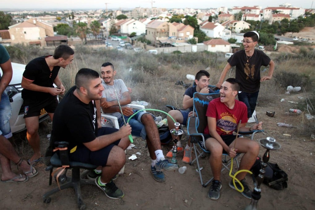 Israeli men gather on a hill overlooking the Gaza Strip to watch Hamas fire rockets fired towards Israel and Israel try to stop them. Photo: EPA