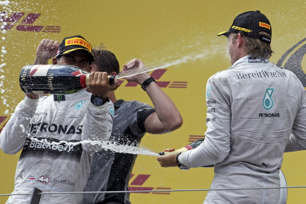 Winner of the Austrain Grand Prix Nico Rosberg of Mercedes and second-placed teammate Lewis Hamilton spray each other with champagne on the podium. Photo: Reuters