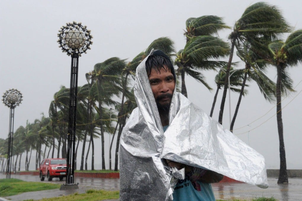 A man walks through heavy wind and rain as Typhoon Rammasun barrels across Manila. Photo: AFP