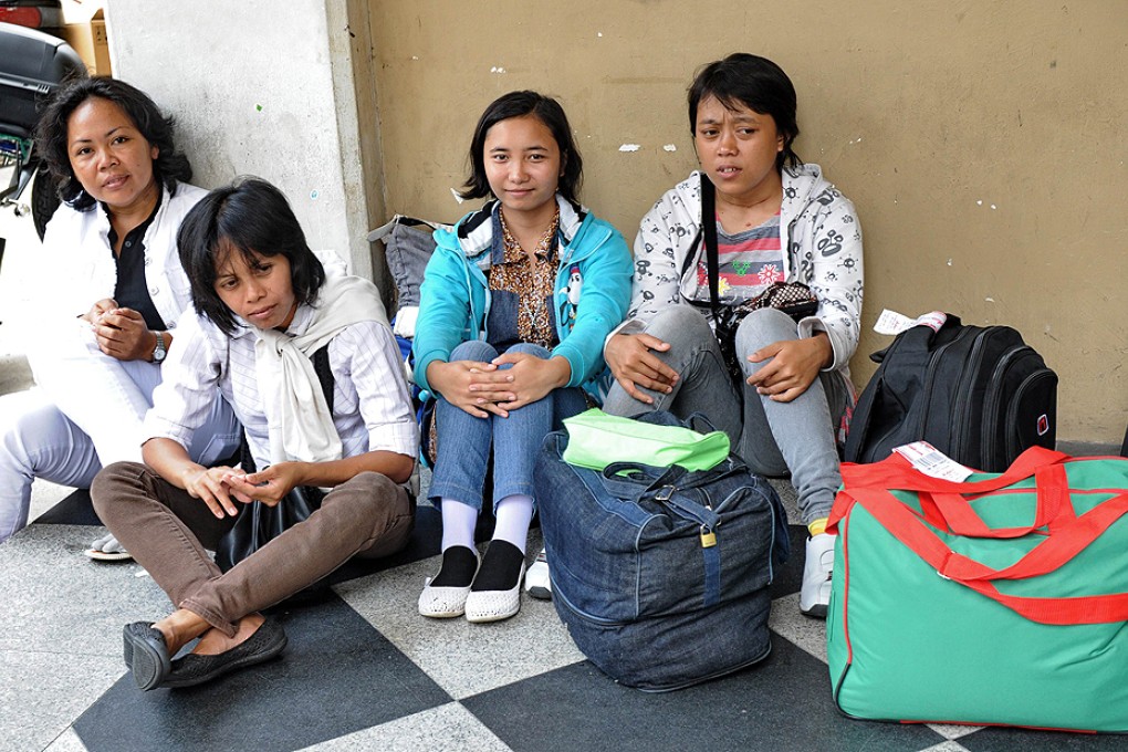 Newly arrived domestic helpers from Indonesia wait for their transportation to a maid agency after going through medical check in Singapore in this file photograph. Photo: AFP