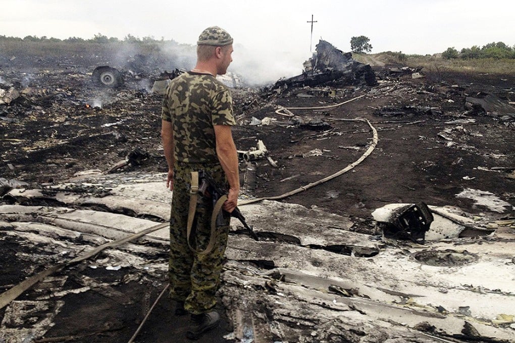 Armed pro-Russian separatist stands at a site of a Malaysia Airlines crash in the settlement of Grabovo. Photo: Reuters
