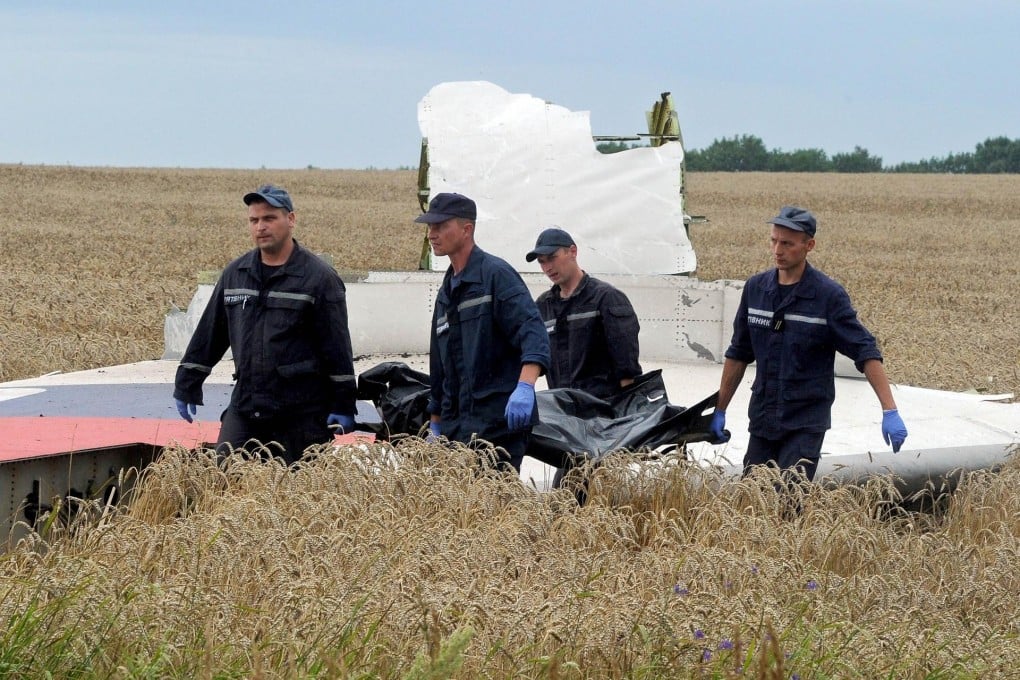 The body of a victim is carried away from the crash site. Photo: AFP