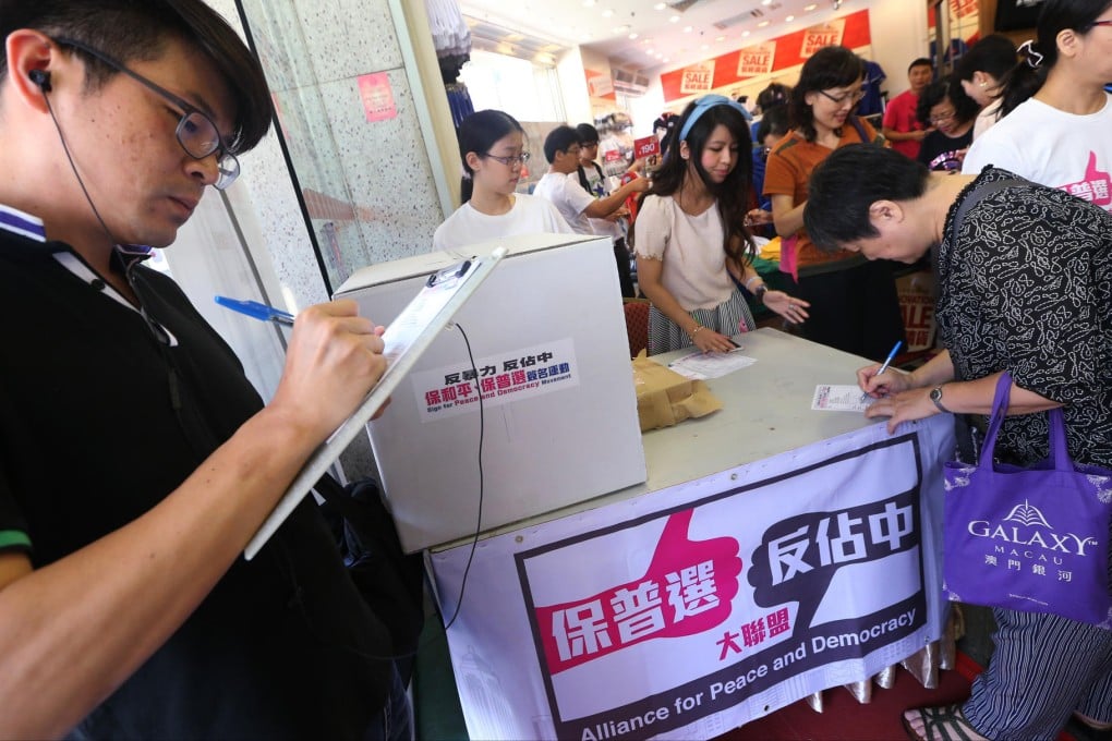 People sign petitions at the Yue Hwa Chinese Products Emporium in Jordan, one of 468 stations across the city. Photo: David Wong