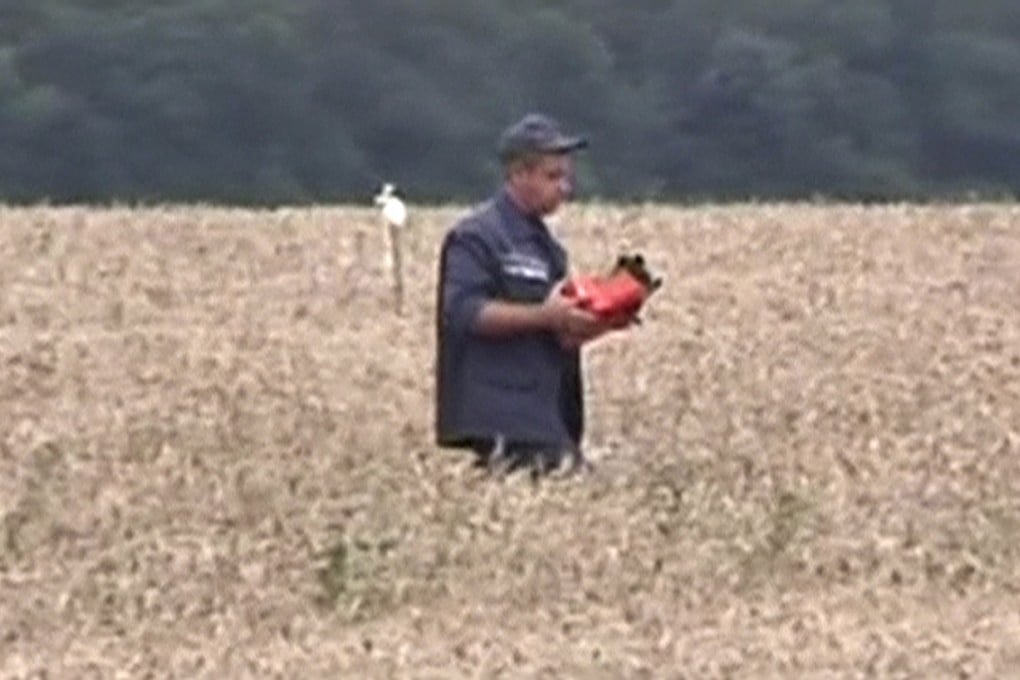 A rescue worker carries a flight data recorder at the crash site of Malaysia Airlines Flight MH17 in eastern Ukraine. Photo: Reuters