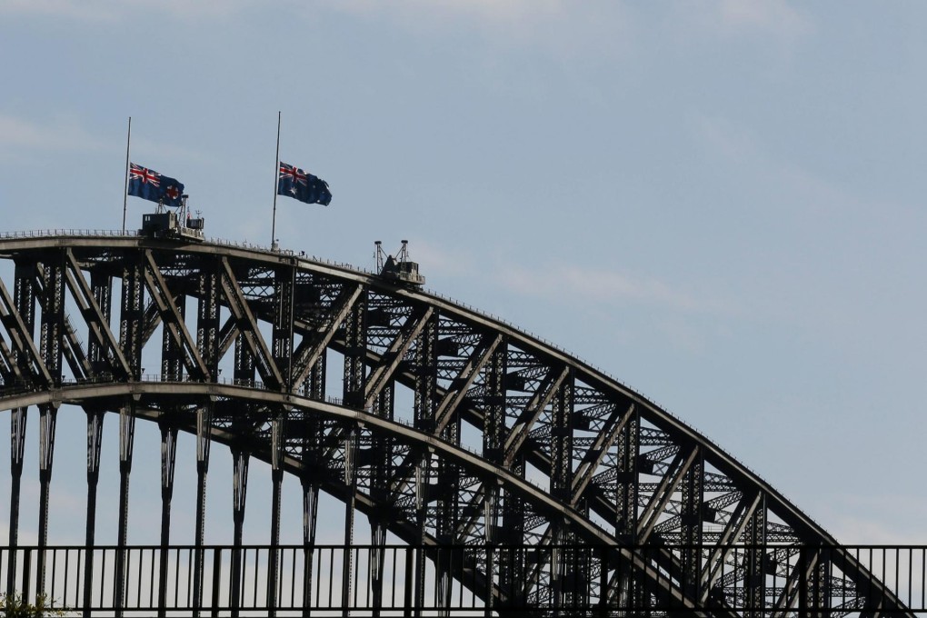 Australian flags fly at half mast in Sydney yesterday. Photo: EPA