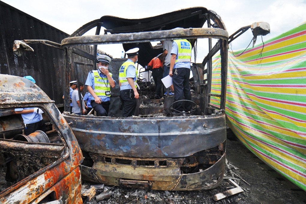 Police inspect the inside of the burned-out bus on the Hukun Expressway after it was hit by a van carrying flammable liquid. Photo: Xinhua