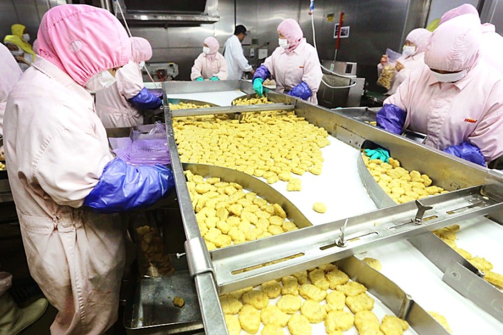 Employees work at the Shanghai Husi Food Company factory before it was raided. Photo: Reuters