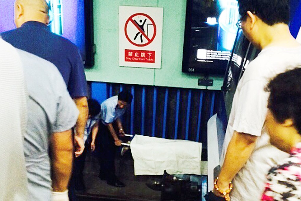The body of a women is removed from the tracks at Xuanwumen station. Photo: SCMP Pictures