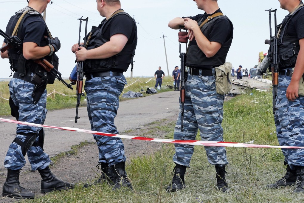 Armed rebel soldiers standing guard at the crash site in eastern Ukraine. Photo: EPA