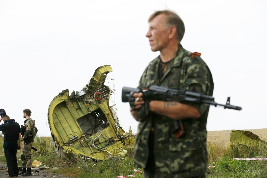An armed pro-Russia separatist stands guard at the crash site of Malaysia Airlines flight 17. Photo: Reuters