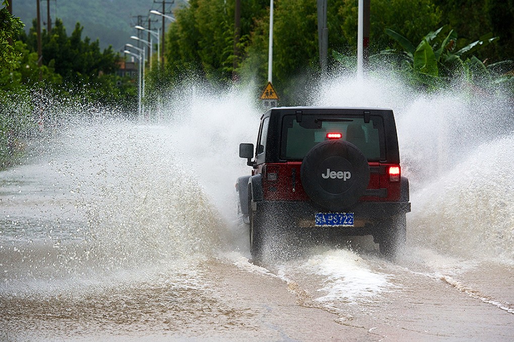 A vehicle makes its way along a waterlogged road in Fuzhou, capital of Fujian province. Photo: Xinhua
