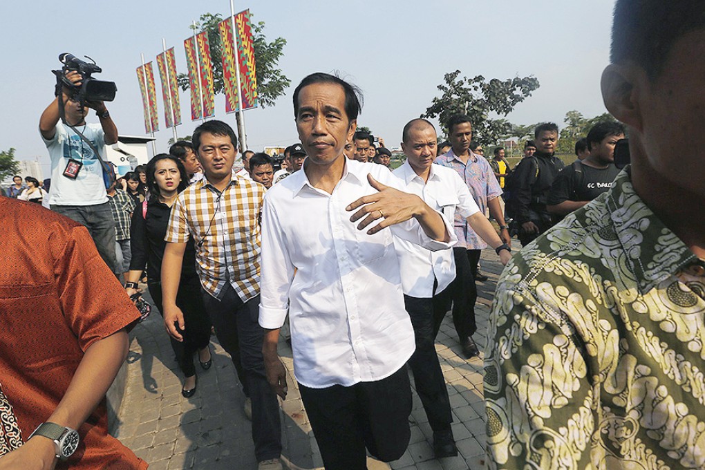 Indonesian presidential candidate Joko "Jokowi" Widodo walks while waiting for the results announcement by the Elections Commission, at Waduk Pluit in Jakarta. Photo: Reuters
