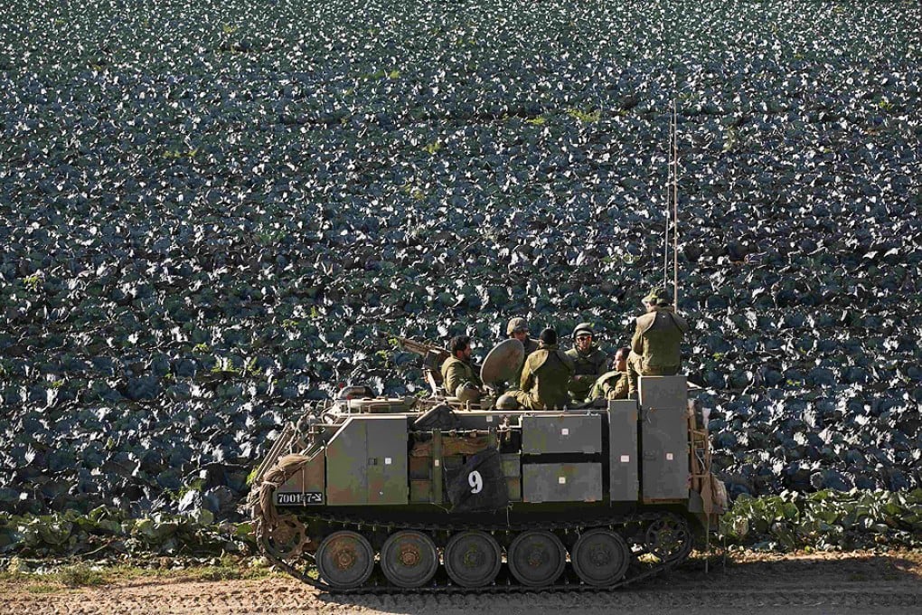 Israeli soldiers ride in an armoured personnel carrier next to a cabbage field near the Gaza Strip. Photo: Reuters