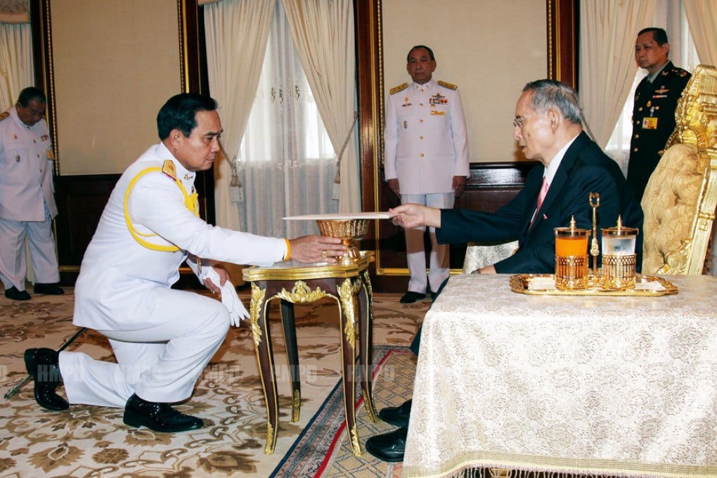 In a photograph released by the palace, junta leader General Prayuth Chan-ocha bows before Thai King Bhumibol Adulyadej, who as endorsed a provisional constitutional charter. Photo: Xinhua