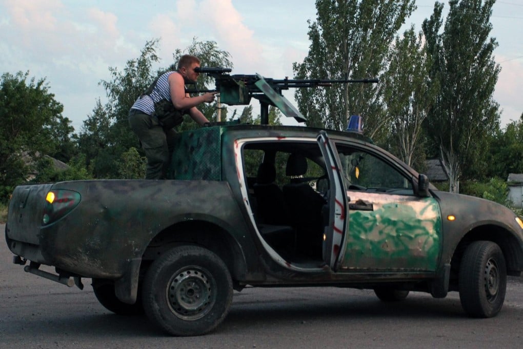 An armed separatist guards a checkpoint near Donetsk. Photo: EPA