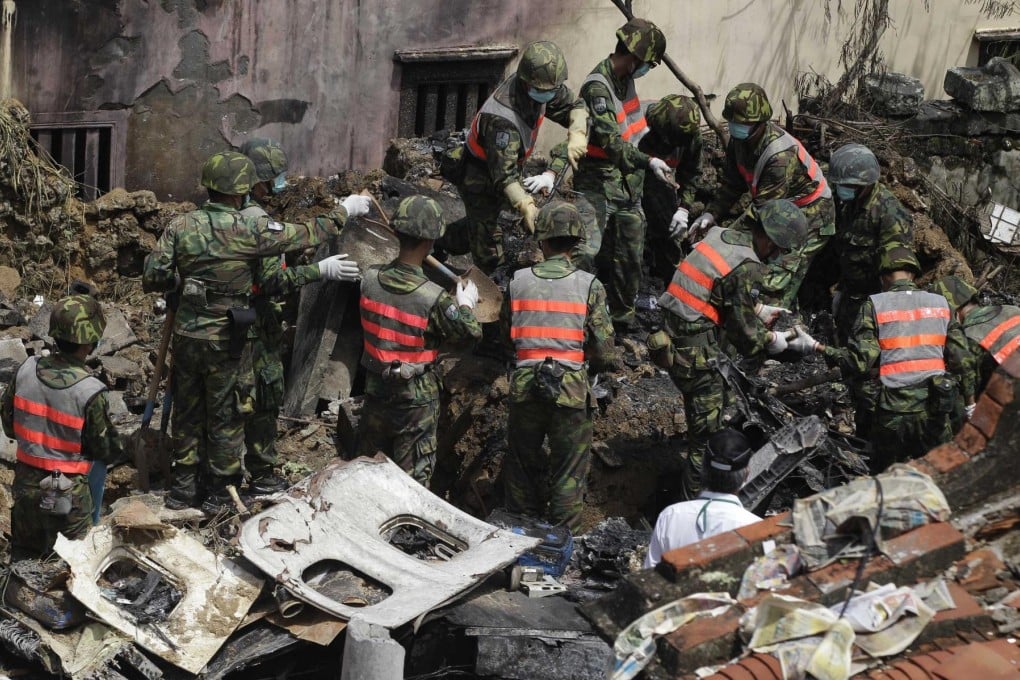 Soldiers clean up the wreckage of the TransAsia Airways turboprop plane that crashed on Penghu island. Photo: Reuters