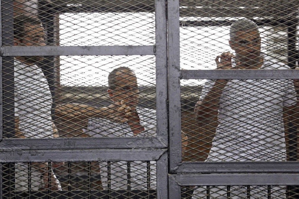 File photo from June 1 of Al-Jazeera journalists Baher Mohammed, Peter Greste and Mohammed Fahmy standing behind bars at a court in Cairo. Photo: Reuters