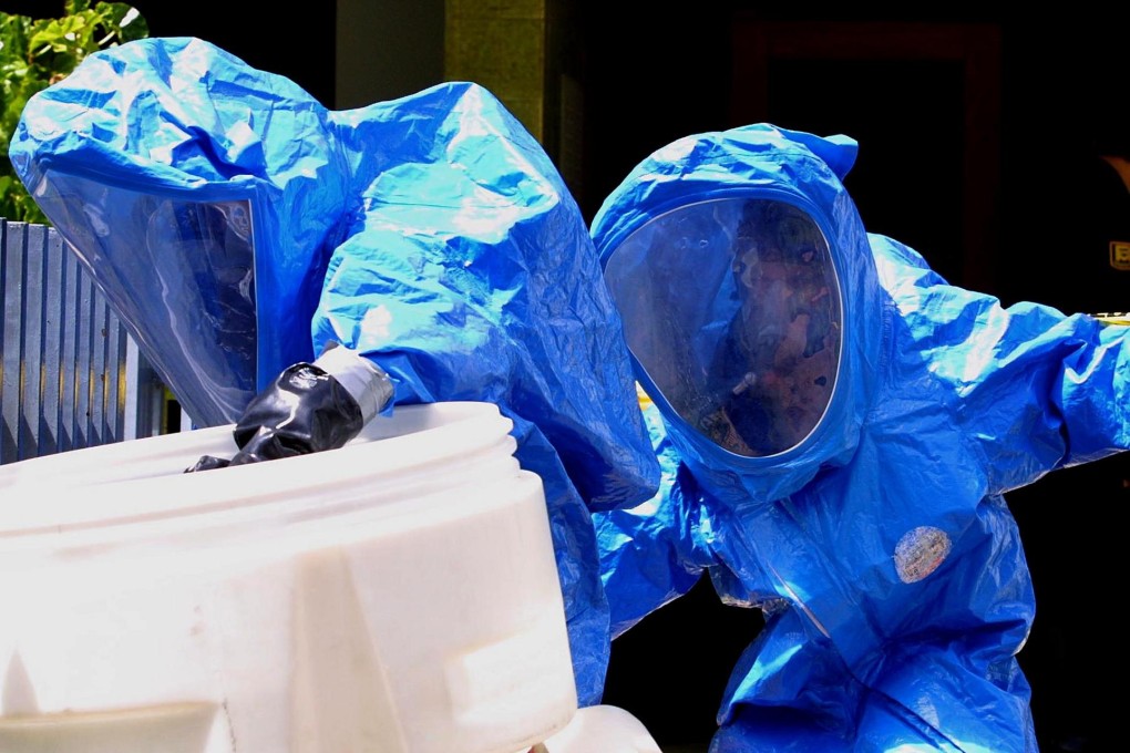 Venezuelan firefighters handle an envelope with suspicious contents that arrived via post, one of a wide array of dangers that can stem from loose control of pathogens. Photo: AFP