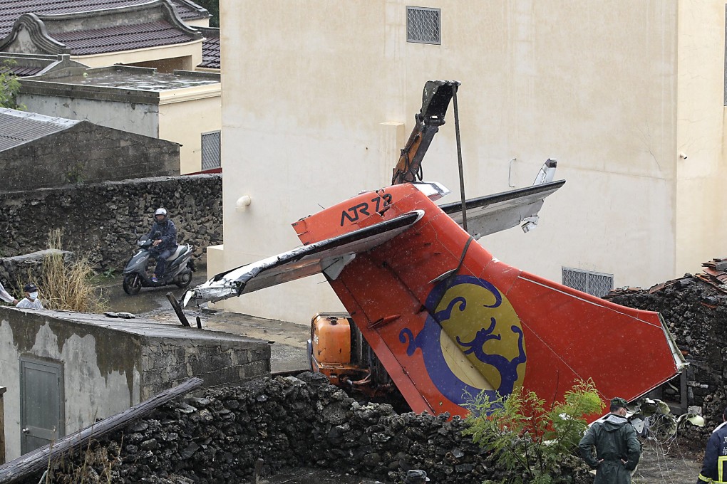Soldiers remove the wreckage of a TransAsia Airways turboprop plane that crashed on the rooftop, on Taiwan's offshore island Penghu. Photo: Reuters