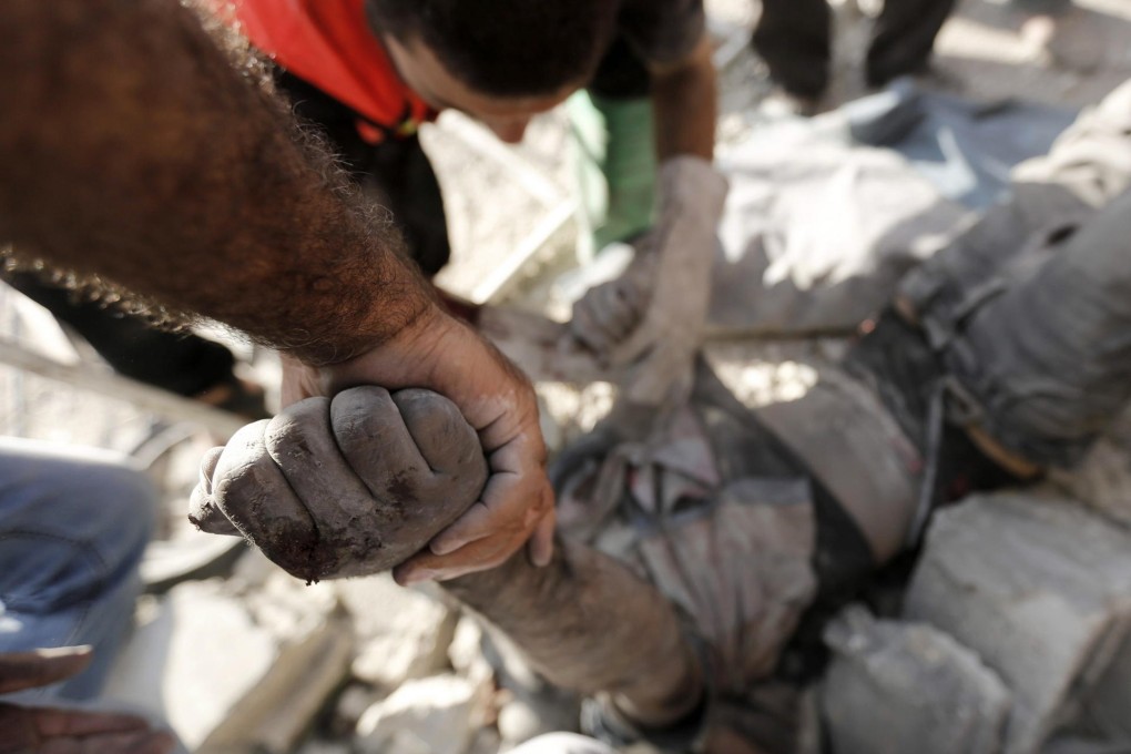 A man's body is removed from under a Beit Hanoun home. Photo: AFP