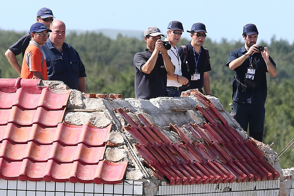 French and Canadian experts on Saturday inspect the site of the TransAsia Airways crash in Taiwan. Photo: AFP