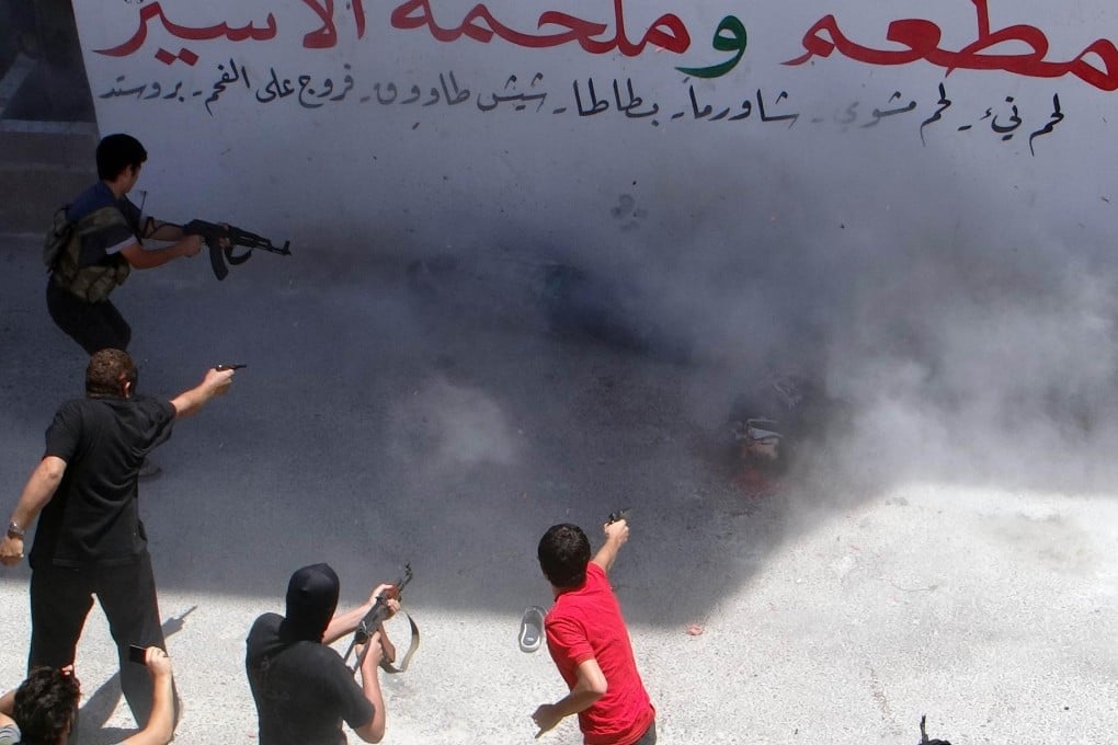 Fighters from the Islamic Front execute two men in Idleb province for allegedly bombing the two main border crossings with Turkey, and a mosque in the town of Binnish, Syria. Photo: AFP
