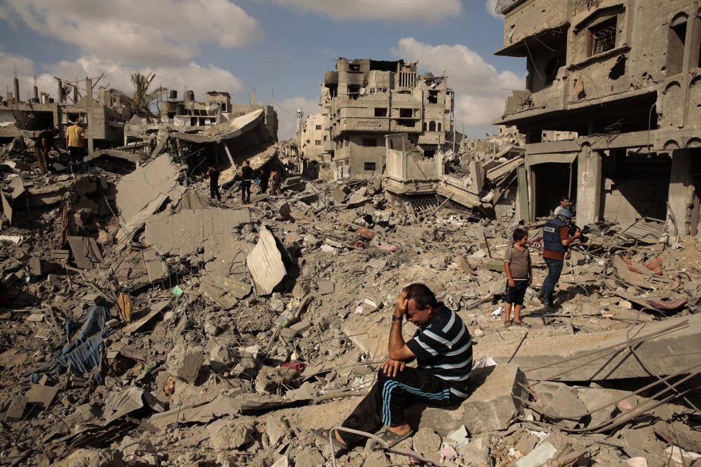 At the start of the ceasefire, a Palestinian man holds his head in despair as he sits amid the rubble of his home in Shejaiya. Photo: MCT