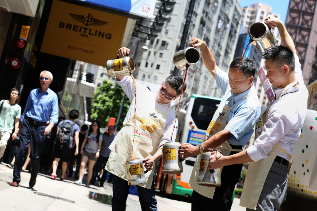 Masters of milk tea (from left) Chan Wai-chung, Leung Tak-chau and Yu Chun-wah show off their skills in Causeway Bay to promote next month's contest. Photo: Nora Tam