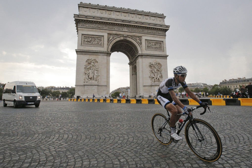 Ji Cheng rides alone as he passes the Arc de Triomphe in the final stage of the Tour. Photo: AP