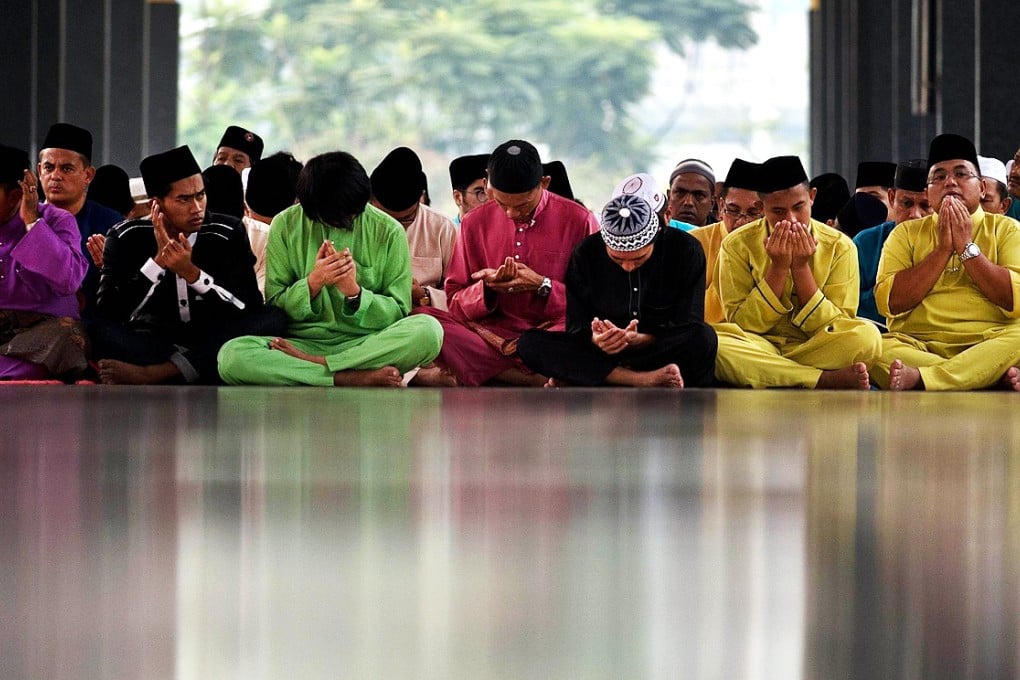 Malaysian Muslims offer prayers at the National Mosque. The victims of two air disasters were in the thoughts of many. Photo: AFP
