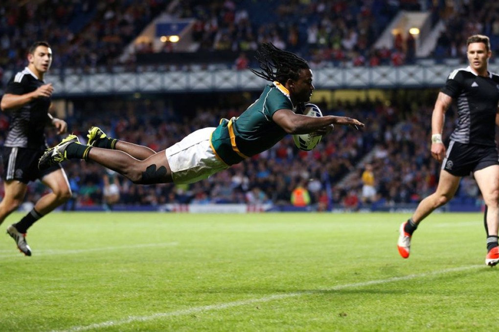Seabelo Senatla of South Africa dives to score a try against New Zealand during the gold medal rugby sevens match at the 2014 Commonwealth Games in Glasgow on Sunday. South Africa shocked the four-time champions with a 17-12 victory. Photo: Reuters