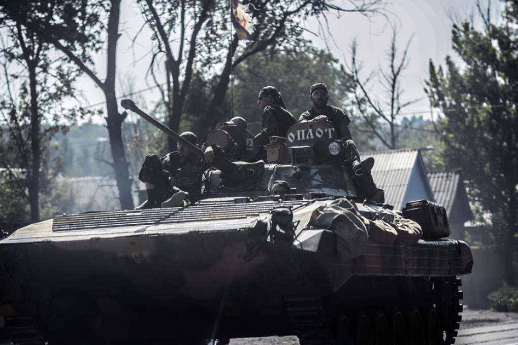 Pro-Russian militants sit on a tank in Donetsk. Photo: AFP