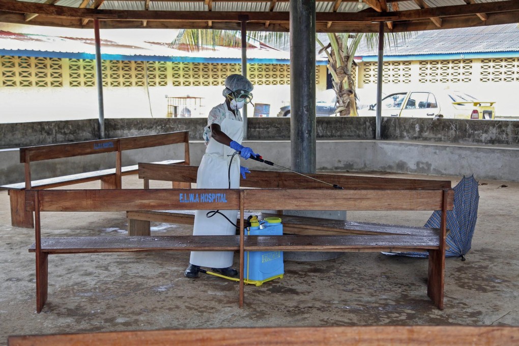 A nurse disinfects a visitors' area at a hospital in Liberia. Ebola has killed more than 670 people in West Africa this year. Photo: EPA