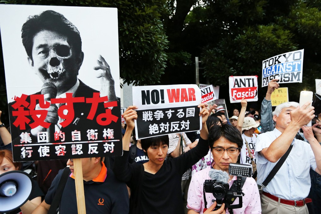 Protesters hold placards and shout anti-government slogans during a rally against Japanese Prime Minister Shinzo Abe's collective self-defense policy which was approved on July 1, 2014. Photo: EPA