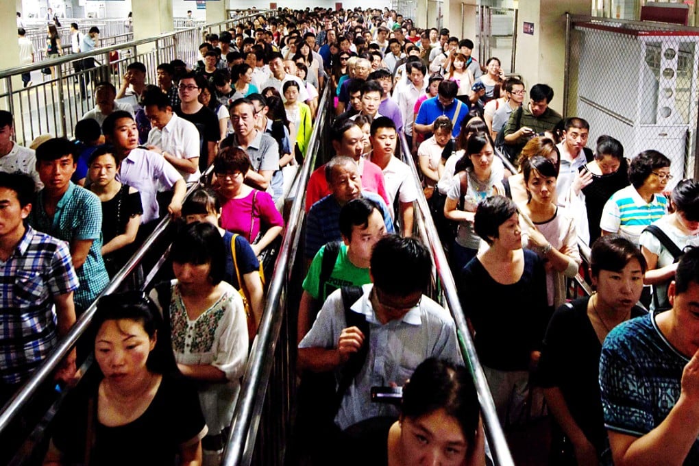 Commuters wait to enter a subway station during the morning rush hour in Beijing. Photo: AFP