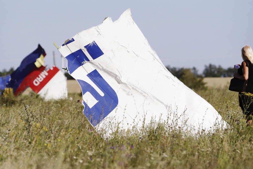 A woman takes a photograph of wreckage at the crash site of Malaysia Airlines Flight MH17 near the village of Hrabove (Grabovo). Photo: Reuters