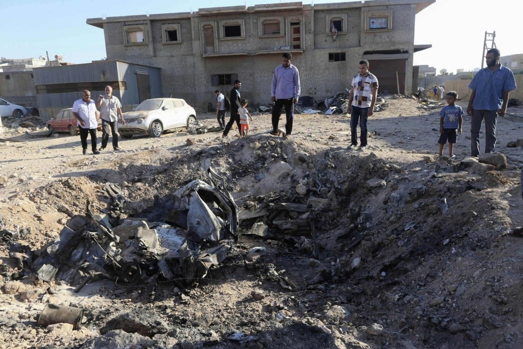 Benghazi residents look at the wreckage of a government MiG fighter, which crashed in the city on Tuesday during fighting that killed 30 people. Photo: Reuters
