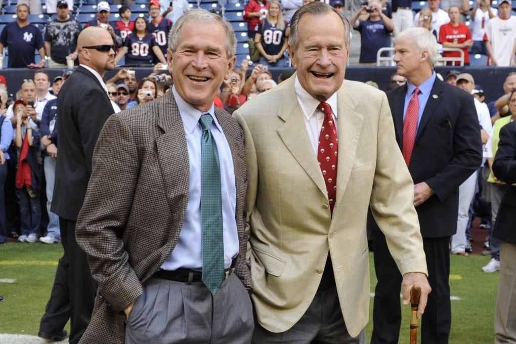 George W. Bush (left) with his father at an NFL game in Houston, Texas. Photo: AP