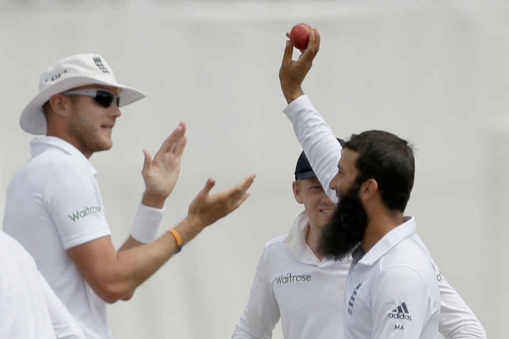 England's Moeen Ali holds up the match ball as he celebrates his fifth wicket - bowling out India's Mohammed Shami - beside his teammate Stuart Broad. Photo: AP