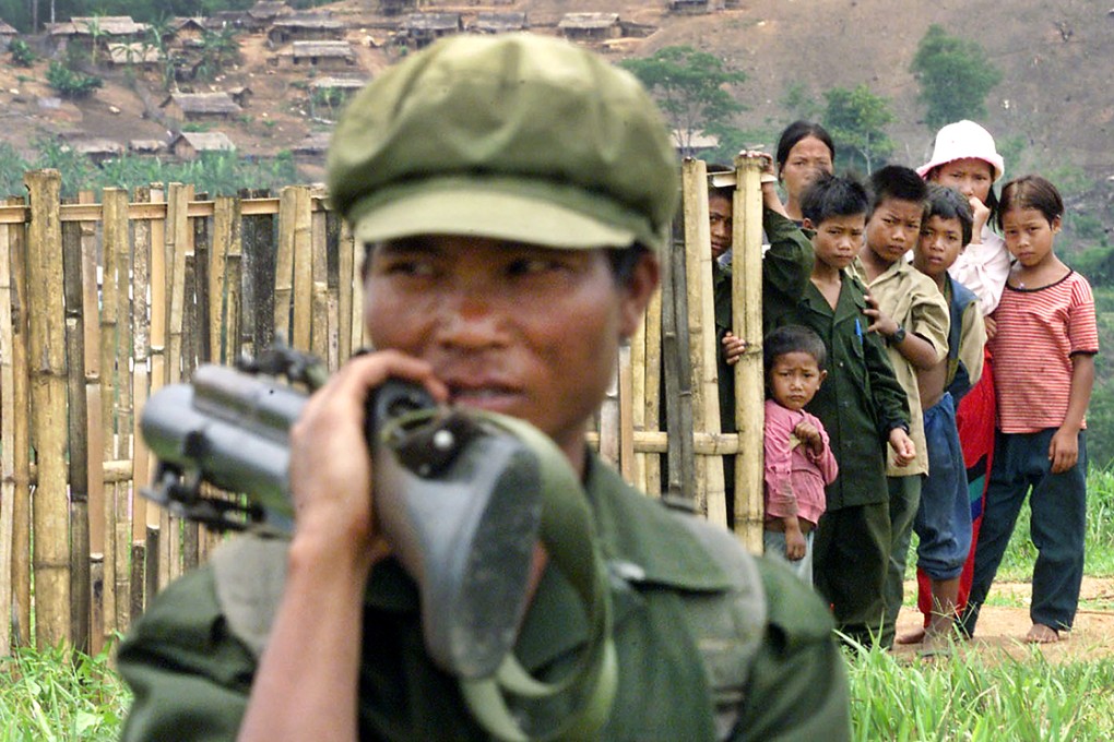 A soldier from Myanmar's Wa Army is watched by young villagers in Mong Yawn May near the border with Thailand. Photo: Reuters